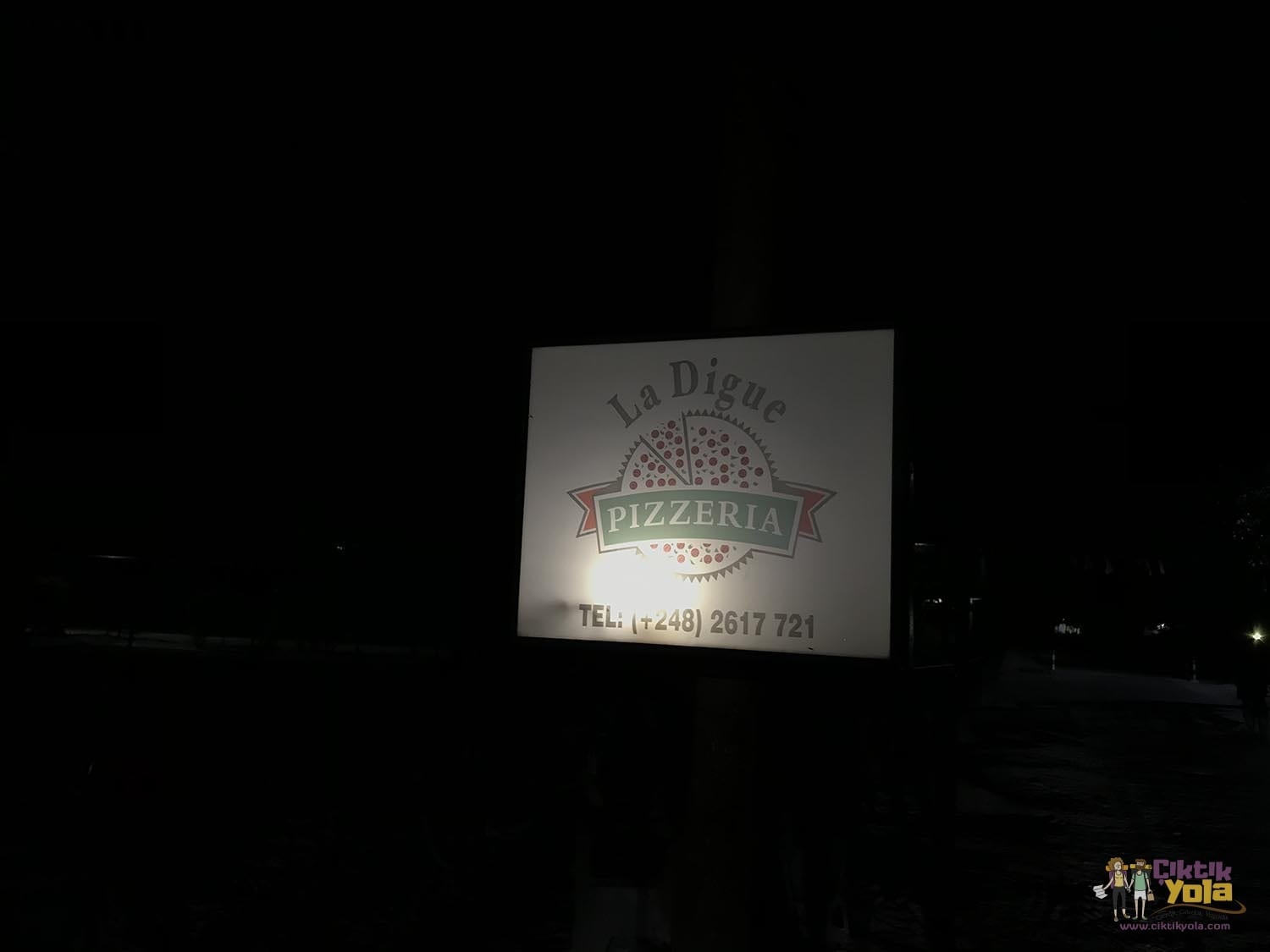 Gece aydınlatılmış La Digue Pizzeria tabelası