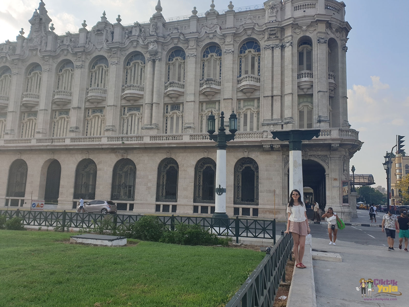 Havana'da süslü taş cepheli tarihi binanın önünde duran kadın